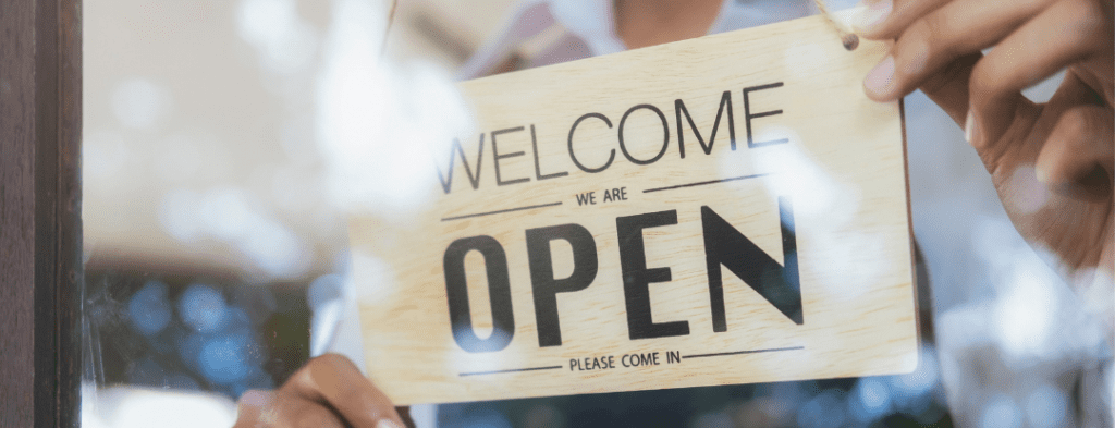 sign in a store window that says welcome we are open please come in